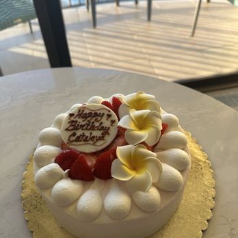 Kulu Kulu - Custom Rainbow cake with strawberries and plumeria flowers. - Coffee & Tea Near Me - Honolulu, Hawaii