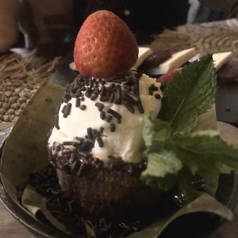 Samba Montclair - Bolo De Chocolate (Flourless Yuca Chocolate Cake with Coconut Ice Cream) - A chocolate dessert with whipped cream, a strawberry, chocolate sprinkles, and a mint leaf on top, served in a small metal dish. - Brazilian Near Me - Montclair, New Jersey