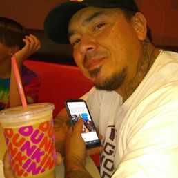  a man holding a drink and a cell phone