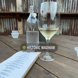 a glass of wine and a menu on a wooden table a glass of wine and a menu on a wooden table