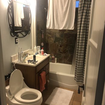 Pacific Craft Construction - Before: Ugly bathroom with odd toilet, oversized vanity relative to the space, and moldy shower tiles. - General Contractors Near Me