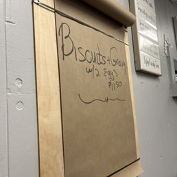 a sign on a wall with a roll of paper attached to it