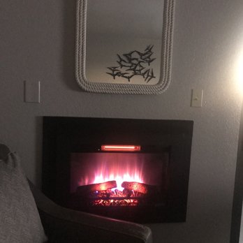 Blue Sail Inn - Fireplace heater next to chair & ottoman.  There were different settings for the fireplace for appearance, warmth, C/F, and even a timer. - Hotels Near Me - Morro Bay, California