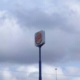 a cloudy sky with a burger king sign