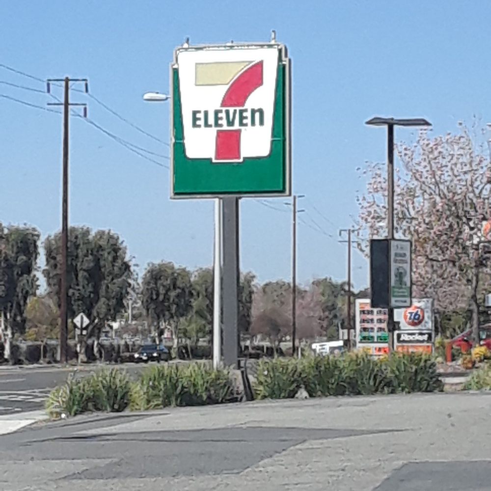 a 7 - eleven sign on the corner of a street