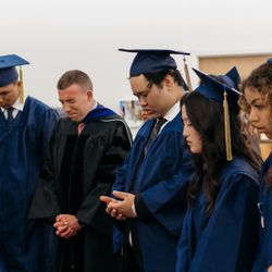 Pacific Bay Christian School - Faculty and students in prayer before graduation. Picture courtesy of Breanna Rhea Photography.