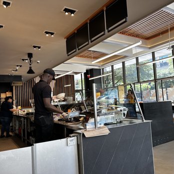 CAVA - a man preparing food in a restaurant - Mediterranean Near Me - Austin, Texas
