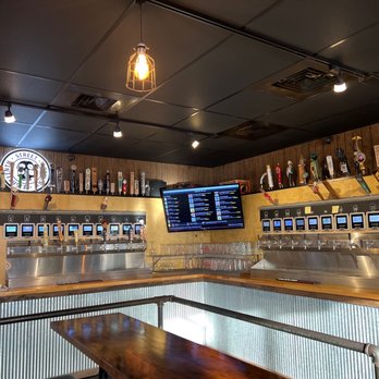 Brewfest - a bar with a long counter and shelves of beer - Beer Gardens Near Me - Highland, Indiana