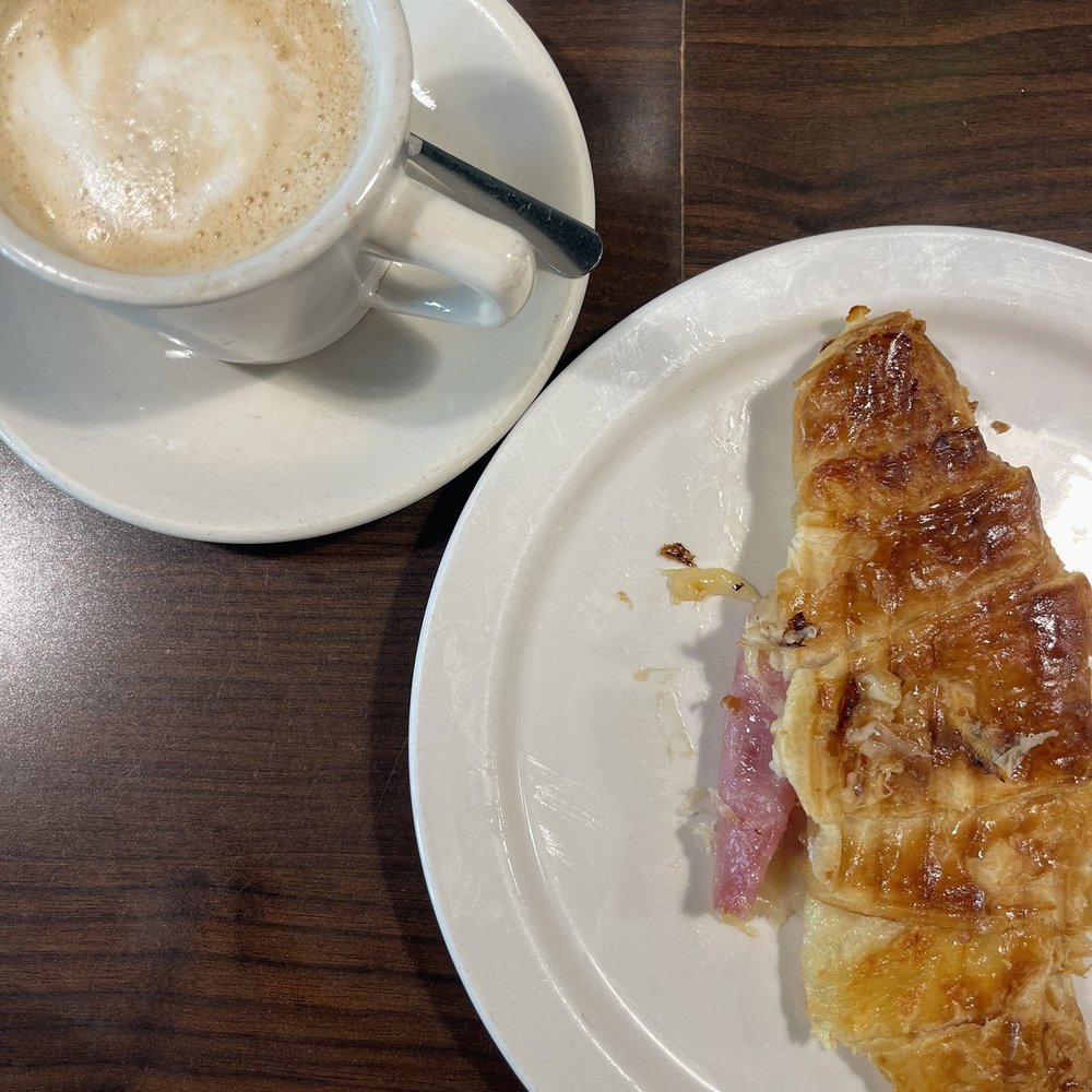 Ham and cheese croissant and a cafe au lait Ham and cheese croissant and a cafe au lait