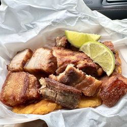 Karibbean Cuisine - Chicharrones Con Tostones. Deep fried pork with fried green plantains and lime. ‍