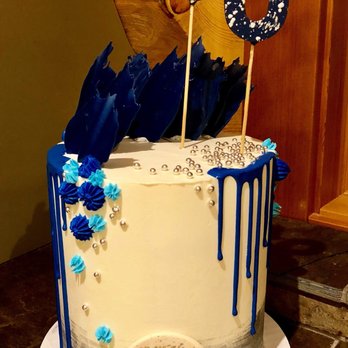 Kake by Darci - a white cake with blue drips and blue flowers - Custom Cakes Near Me - Canmore, Alberta