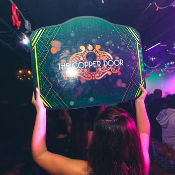 The Copper Door - a woman holding up a sign - Dance Clubs Near Me - Santa Ana, California The Copper Door - a woman holding up a sign - Dance Clubs Near Me - Santa Ana, California