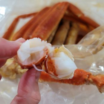 Crazy Crab - a hand holding a crab claw - Cajun/Creole Near Me - Streamwood, Illinois