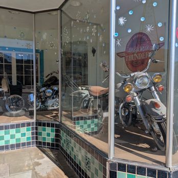Ghost Town - Two motorcycles are visible inside a glass storefront with holiday snowflake and dot decorations. - Local Flavor Near Me - Bisbee, Arizona