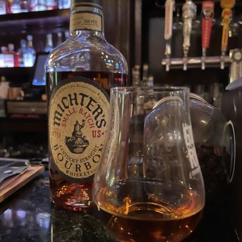 Bourbon Room - Michters bourbon bottle with a glass (with bourbon). Bottles of bourbon are in the background. - Whiskey Bars Near Me - Saratoga Springs, New York Bourbon Room - Michters bourbon bottle with a glass (with bourbon). Bottles of bourbon are in the background. - Whiskey Bars Near Me - Saratoga Springs, New York