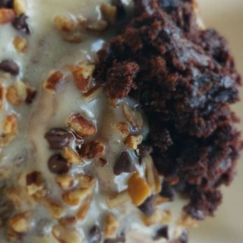Cinnaholic - Side view of Cinnamon roll topped with caramel icing, chocolate chips, pecans, and brownie bits - Bakeries Near Me - Pearland, Texas Cinnaholic - Side view of Cinnamon roll topped with caramel icing, chocolate chips, pecans, and brownie bits - Bakeries Near Me - Pearland, Texas