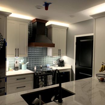Vrapi Construction - a kitchen with a sink, stove, and refrigerator - General Contractors Near Me