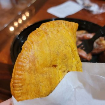 Back A Yard Caribbean Grill - a hand holding a taco - Caribbean Near Me - Campbell, California