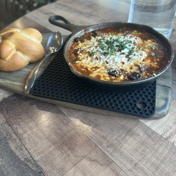Café Alma - SHAKSHUKA- Poached eggs in our housemade shakshuka tomato base with roasted eggplant, kalamata olives, chili flakes, and feta cheese. - Breakfast & Brunch Near Me - Cincinnati, Ohio Café Alma - SHAKSHUKA- Poached eggs in our housemade shakshuka tomato base with roasted eggplant, kalamata olives, chili flakes, and feta cheese. - Breakfast & Brunch Near Me - Cincinnati, Ohio