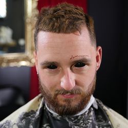 Textured hair on top styled with product to give it that matte look. Shear work on top. A sharp beard line up. By damnsam
