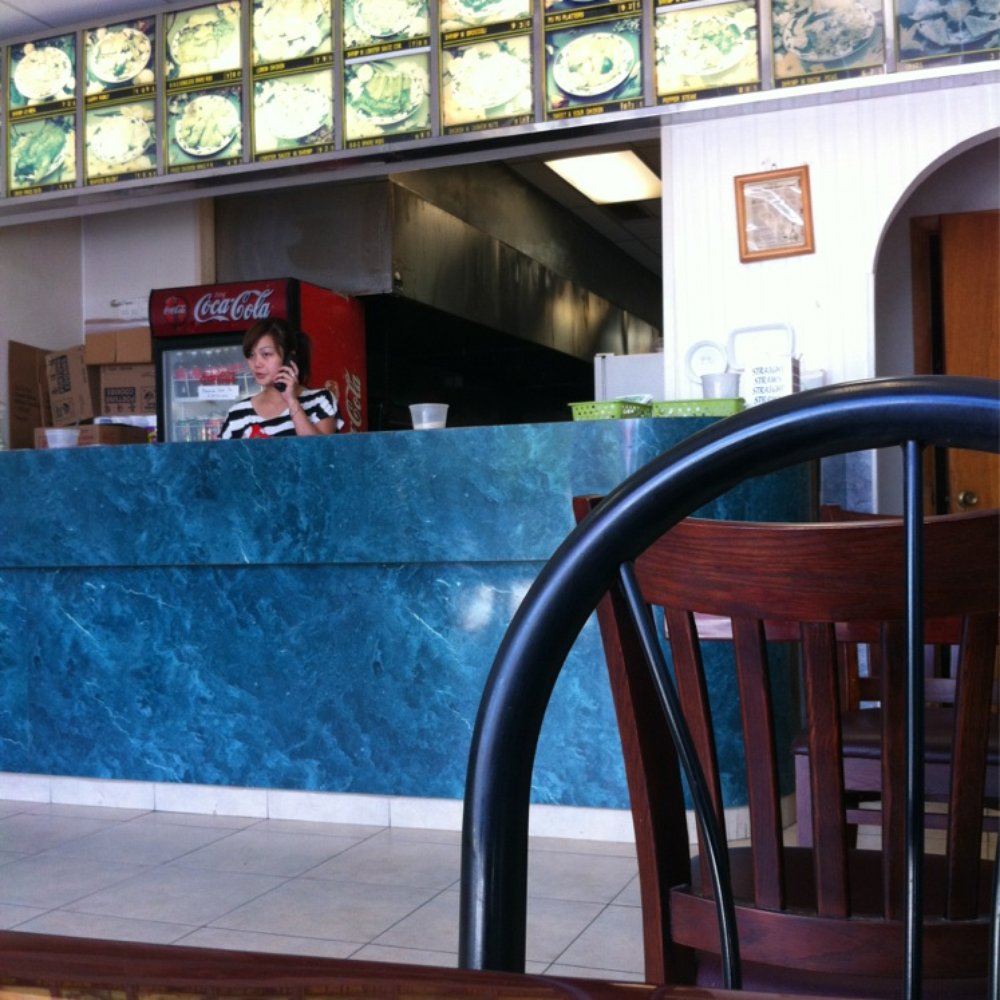 a woman sitting at a restaurant counter a woman sitting at a restaurant counter