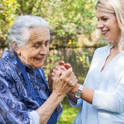 Egis Complete Care - Caregiver supporting client walking outside.
