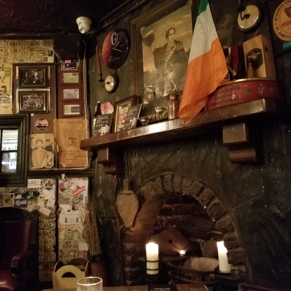 The Brazen Head - Fire place is for show.  Some of the many dollar bills covering the walls to the left. - Pubs Near Me - Dublin, D