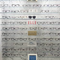 Premier Vision Care Optometry - A curated wall of designer eyewear featuring brands like Prodesign, ELLE, and Esprit--style meets vision at Premier Vision Care.