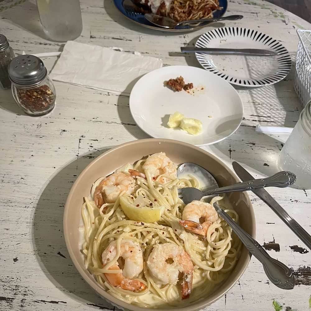 Shrimp scampi up close and eggplant Parmesan across the table. Shrimp scampi up close and eggplant Parmesan across the table.