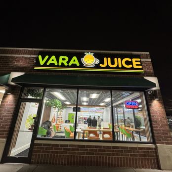 Vara juice - storefront at night - Vara Juice, a natural smoothie bar in Bridgeview, IL, features a brightly lit sign and large glass windows showing the interior with customers and staff. - Juice Bars & Smoothies Near Me - Bridgeview, Illinois
