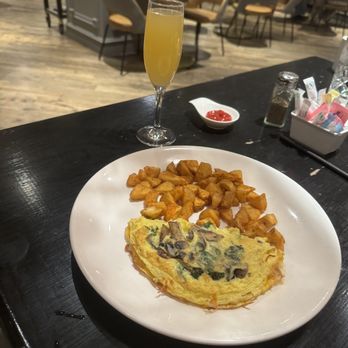 The Preston - Spinach and mushroom omelette with cheddar cheese. Mimosa highlights the background!! - Breakfast & Brunch Near Me - St Louis, Missouri