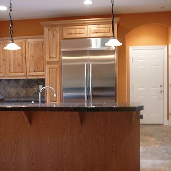 Craftsman Construction - a kitchen with wood cabinets and stainless steel appliances - General Contractors Near Me - Beaverton, Oregon