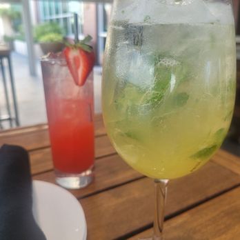 The Landing RoofTop - STRAWBERRY SUNSET (Back): Strawberry puree, lemon, syrup, sparkling water.  LEMON BAY BREEZE (Front): Lemon, honey, basil, sparkling water. - Comfort Food Near Me - Melbourne, Florida