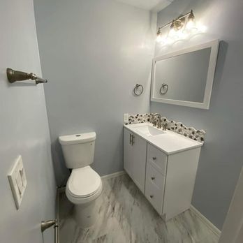 Avanti Construction - a bathroom with a toilet, sink, and mirror - General Contractors Near Me - Chula Vista, California Avanti Construction - a bathroom with a toilet, sink, and mirror - General Contractors Near Me - Chula Vista, California