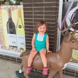 Lizz's Liquor Store - My daughter sitting on the famous deer of Lizz's Wine and Spirits.
