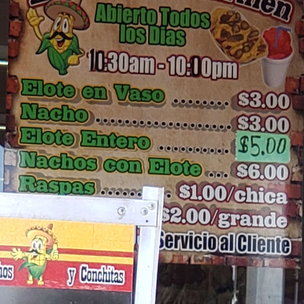 Elotes Dona Carmen - a man eating a hot dog - Food Stands Near Me Elotes Dona Carmen - a man eating a hot dog - Food Stands Near Me