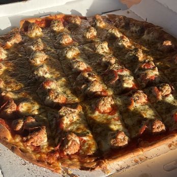 Villa Nova Stickney - A rectangular pizza with sausage pieces and melted cheese in a pizza box on a wooden table. - Pizza Near Me - Stickney, Illinois