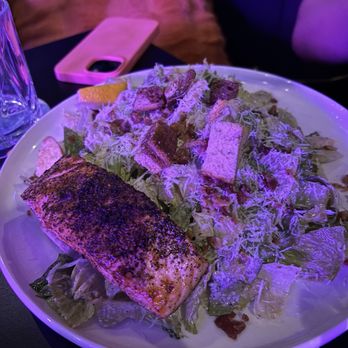 Culinary Unicorn - CAESAR SALAD Crisp romaine tossed with anchovy Caesar dressing, parmesan, bacon bits, fried capers, croutons, and a lemon wheel w/ Salmon - Cocktail Bars Near Me - Edmonton, Alberta Culinary Unicorn - CAESAR SALAD Crisp romaine tossed with anchovy Caesar dressing, parmesan, bacon bits, fried capers, croutons, and a lemon wheel w/ Salmon - Cocktail Bars Near Me - Edmonton, Alberta