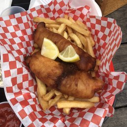 Way too much food - A serving of fish and chips with lemon wedges and French fries on red and white checkered paper, served outdoors.