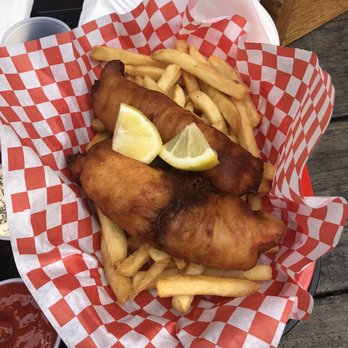 Nosh Shop - Way too much food - A serving of fish and chips with lemon wedges and French fries on red and white checkered paper, served outdoors. - Food Trucks Near Me - Eugene, Oregon