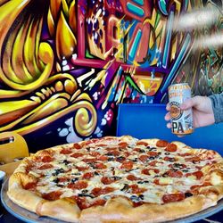 Spinelli's - Comparison photo of hand with beer and the pizza