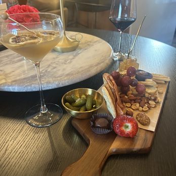 Stafford House Provisions - a cheese board with fruit, olives, and a glass of wine - Steakhouses Near Me - Denison, Texas