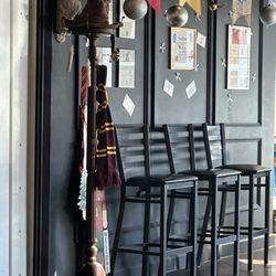 Capital Thai - A coat rack with the sorting hat and some Gryffindor accessories, floating candles, and Hogwarts house banners and Hogwarts themed wall art