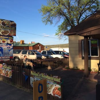 Nalini's Restaurant - a man sitting at a table in front of a restaurant - Mexican Near Me - Parachute, Colorado