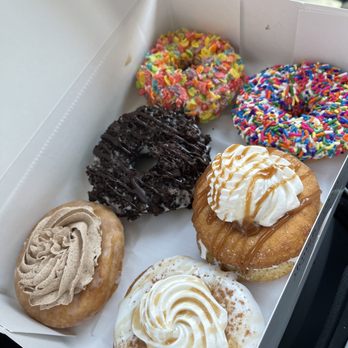 Doughology - Lynbrook - Doughnuts listed from top left: Cinnamon Bun, Chocolate Oreo Donut, Fruity Pebbles, French Toast, Churro, Vanilla Sprinkled Donut - Donuts Near Me - Lynbrook, New York