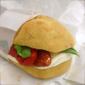 Russo Mozzarella & Pasta - The "Caprese" sandwich prepared with fresh mozzarella, sun dried tomato, basil leaves and drizzled with olive oil. - Cheese Shops Near Me - New York, New York