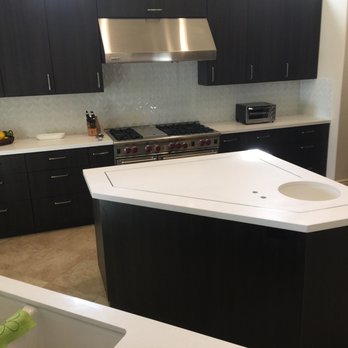 Phoenix Stone - a kitchen with black cabinets and white countertops - General Contractors Near Me - San Jacinto, California