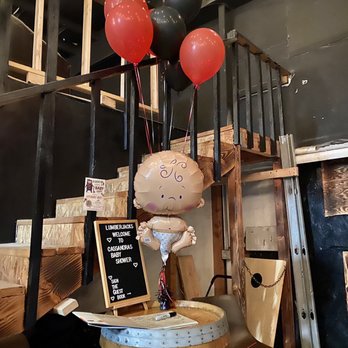 The Axe Lair - a table with balloons and a sign - Axe Throwing Near Me - Upland, California