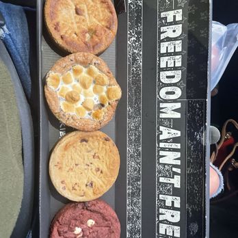 Cookie Plug - Peanut butter, smores, Og, red velvet - A rectangular box contains four cookies with different flavors: peanut butter, s'mores, OG, and red velvet, arranged in a row. - Desserts Near Me - Avondale, Arizona