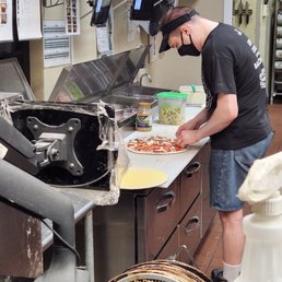 Employee making pizza not wearing gloves